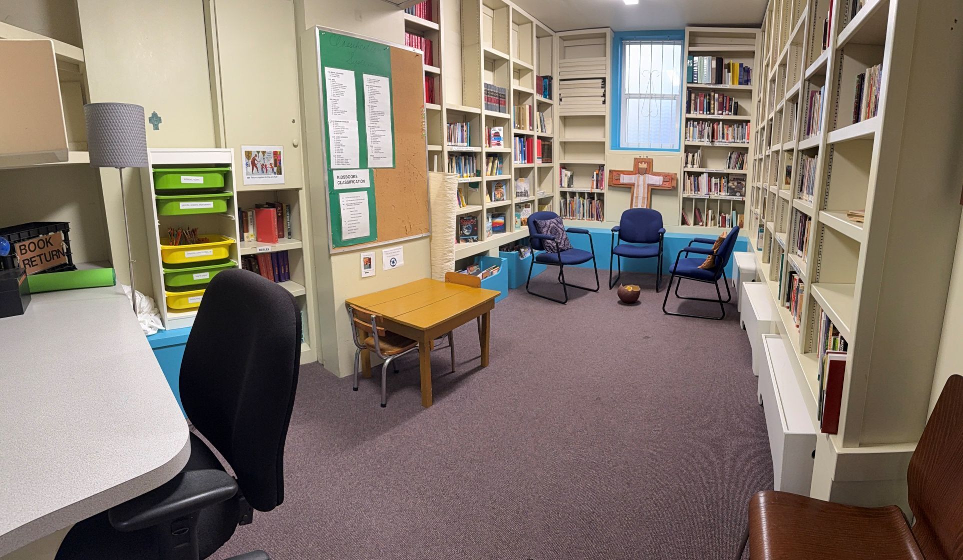 photo of a small room with three chairs lined with books on the walls