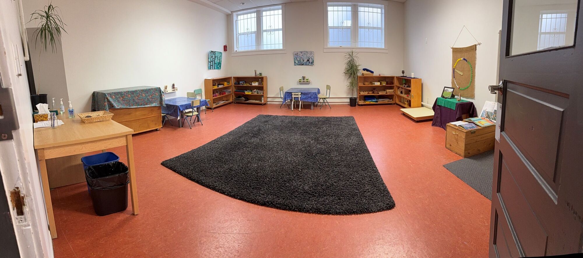 photo of a larger classroom with preschool deskschairs and a big carpet